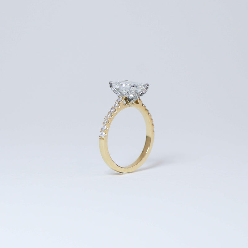 Radiant cut diamond fleur ring with diamond set band.