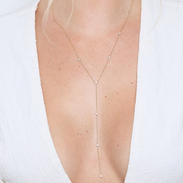 Diamond lariat necklace on neck.